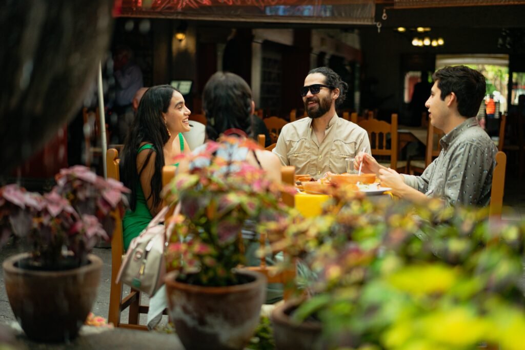 Friends enjoying a meal and conversation in a lively Mexican restaurant setting.